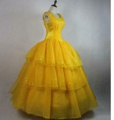 a yellow ball gown is shown on a mannequin