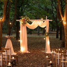 an outdoor wedding ceremony set up with pink drapes and white flowers on the altar