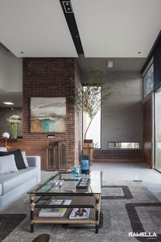 a living room with couches, coffee table and paintings on the wall in it