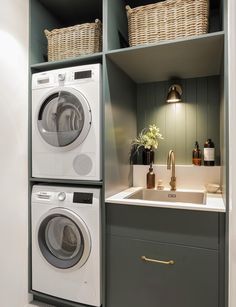 a washer and dryer in a laundry room with baskets on the shelves above