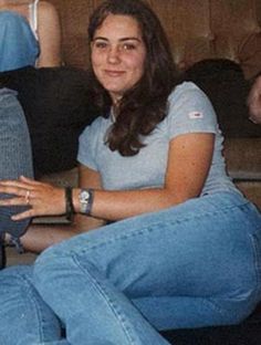 a woman is sitting on the couch with her legs crossed and smiling at the camera