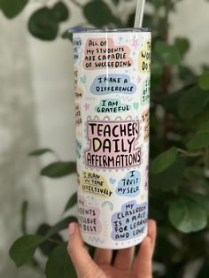 a person holding up a tumbler with writing on it and the words teacher's daily affirmations