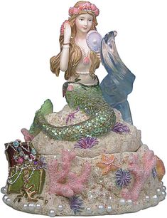 a mermaid figurine sitting on top of a rock