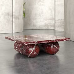 a red marble coffee table with three balls on each side and a plant in the middle