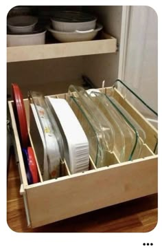 an open drawer in a kitchen filled with dishes