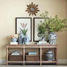 two vases with plants are on a shelf