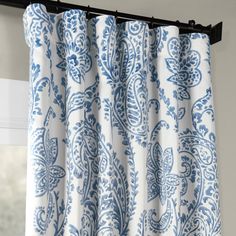 a blue and white curtain hanging on the side of a window