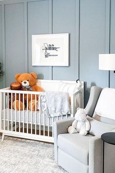 a baby's room with a crib, chair and teddy bear in it