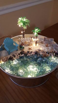 a beach scene made out of rocks and sea glass with palm trees in the background