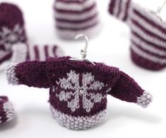 some knitted items are sitting on a white table and one has a hook in it