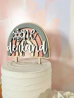 a cake topper that says we deliverland on it with a rainbow in the middle