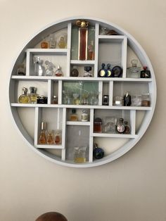 a white circular shelf filled with lots of bottles