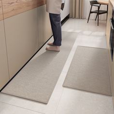 a woman standing in a kitchen next to a counter