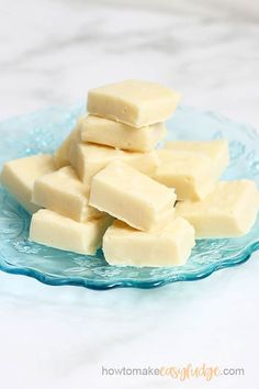 a blue glass plate topped with pieces of white fudge next to a marble counter top