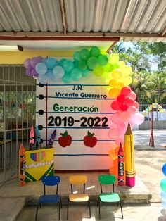 the entrance to an elementary school with balloons and crayons in front of it