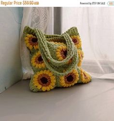 a crocheted sunflower purse sitting on a window sill next to a curtain