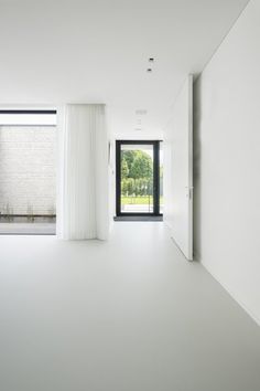 an empty room with white walls and curtains