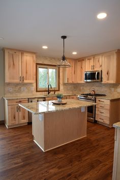 a large kitchen with wooden cabinets and an island