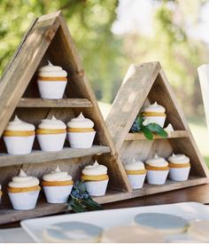 cupcakes are arranged in triangle shaped wooden trays