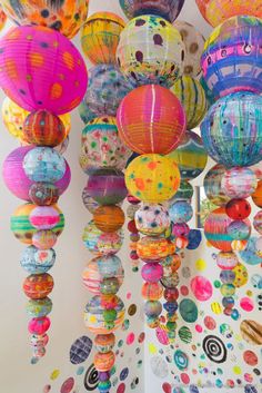 many colorful paper lanterns hanging from the ceiling