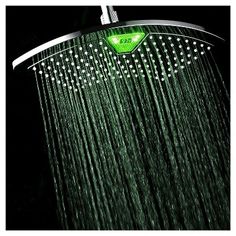 a shower head with water running down it's side and red heart on the top