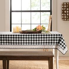 a table with a black and white checkered tablecloth on it next to a window