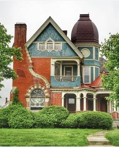 an old victorian style house with blue and red trim