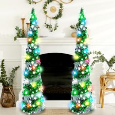 a decorated christmas tree sitting in front of a fire place with lights on it's sides