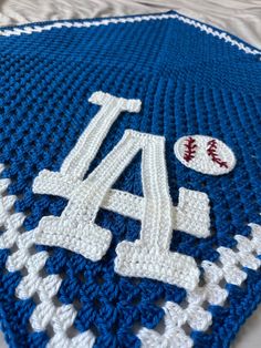 a crocheted blanket with the number four on it and a baseball in the middle