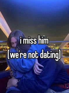 a woman hugging her boyfriend while he is on the roof of a building at night