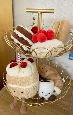 three tiered tray holding stuffed animals and cakes