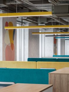 an empty office with blue and yellow couches