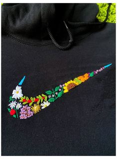 a black hoodie with colorful embroidered flowers on it