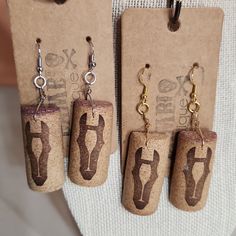 three pairs of cork earrings hanging from hooks