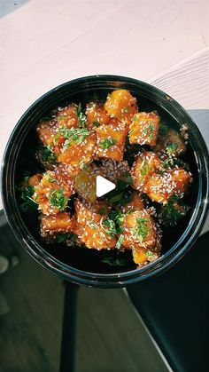 a black bowl filled with food on top of a table