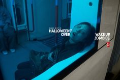 a woman laying down on a train with the words halloween's over wake up zombies