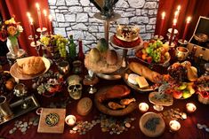 a table topped with lots of food and candles