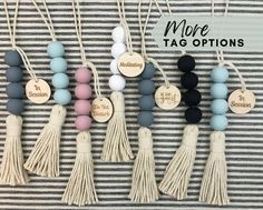 some tasselled beads are hanging on a wall with tags and tassels