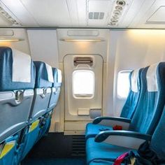 two seats in an airplane with blue carpet and white walls, one facing the other