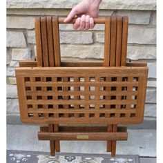 a wooden chair with a hand on it's back that is holding the seat