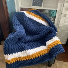 a crocheted blanket sitting on top of a chair next to a fire place