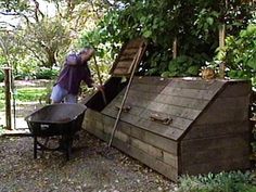 a man pushing a wheelbarrow out of a wooden shed