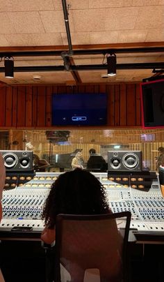 two people sitting in front of sound mixing equipment