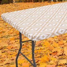 an ironing board sitting on top of a table covered in leaves