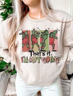 "Sweatshirt Details: // This listing includes One sweatshirt or short sleeve tshirt // Cotton & Polyester Blend - extra soft feel // Fleece lined, light weight, but warm // Graphic shows a green christmas character stomping and a quote that says \"That's it I'm not going\" // These are Unisex sized shirts // Plus Size Available TURNAROUND TIME: // Roughly 5 days + shipping (due to holiday volume the closer to Christmas, the longer the turnaround will be) // If you need this item by a particular Holiday Tees, Funny Christmas Sweater, Shirts Plus Size, Sweatshirt Details, Funny Christmas Sweaters, Popular Shirt, Green Christmas, Retro Christmas, Funny Christmas