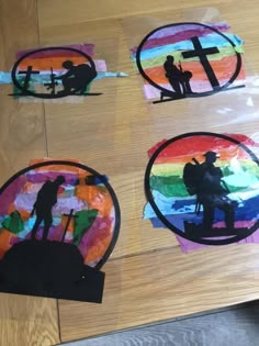 four different colored paper cutouts on a wooden surface with the silhouettes of people