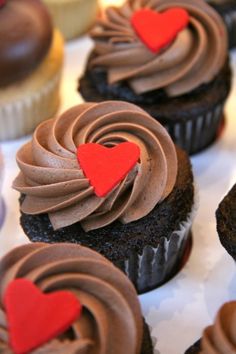 cupcakes with chocolate frosting and hearts on them