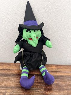 a green stuffed animal wearing a witch costume