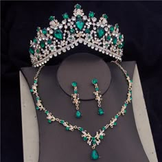 a green and white tiara with matching jewelry set on top of a display case