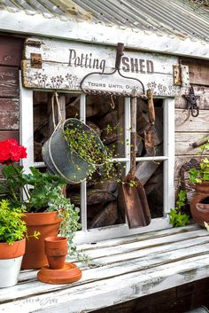 an old window with pots and pans hanging from it's side, filled with plants